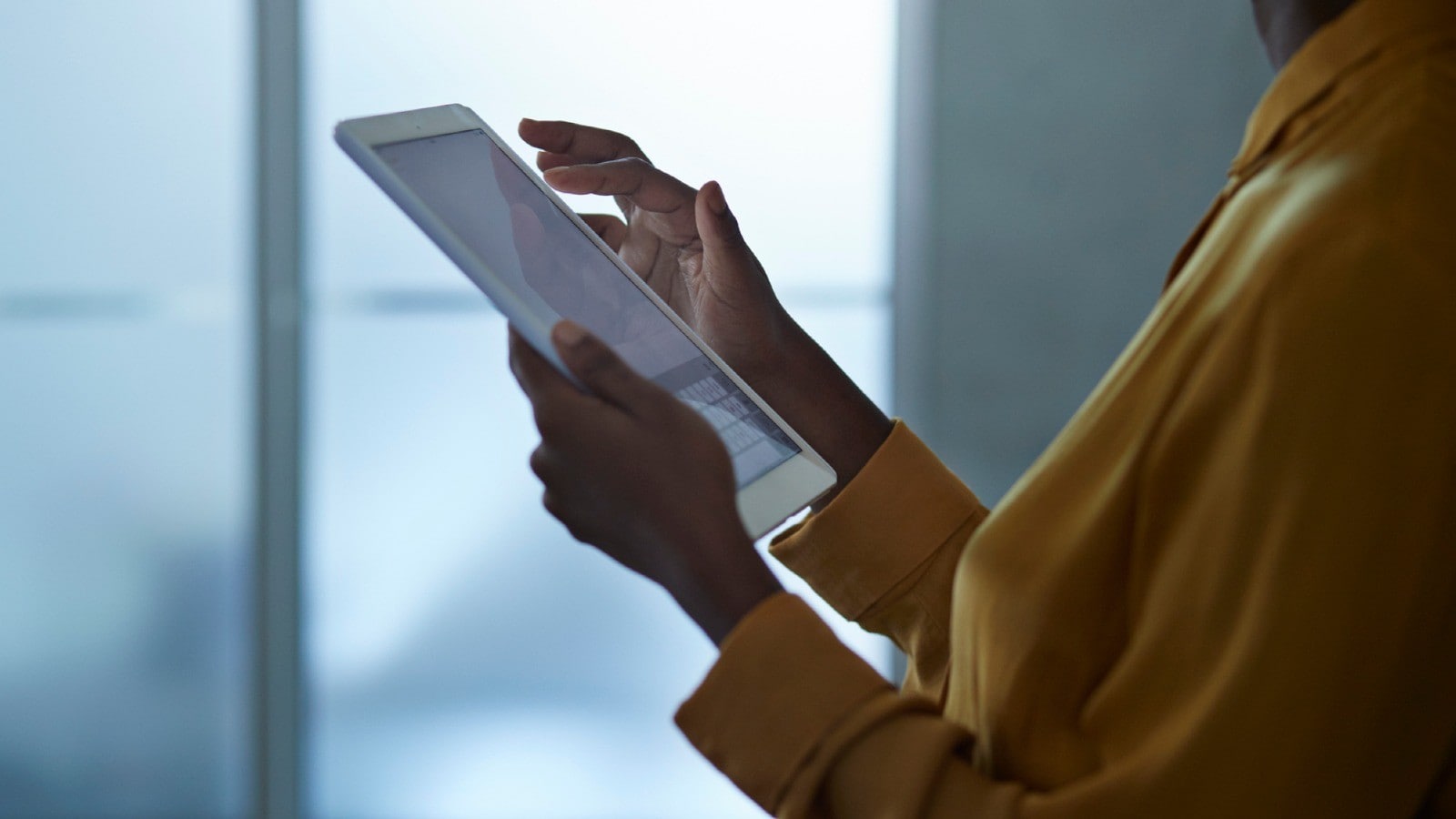 Woman reading about consulting and risk services on her tablet.